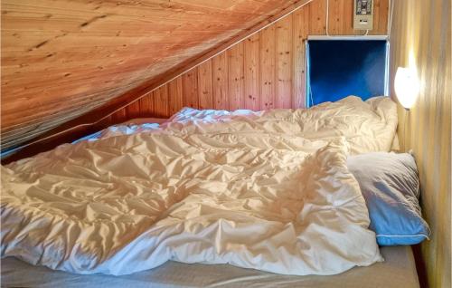 リュングダールにある1 Bedroom Nice Home In Lyngdalの木製の壁の客室で、ベッドメイキングは行っていません。