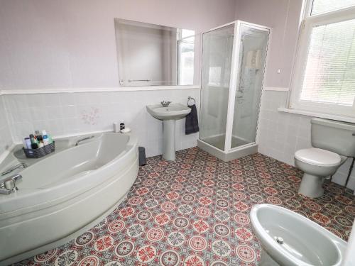 Un baño con bañera, inodoro y lavabo. en Number 91, en Belfast