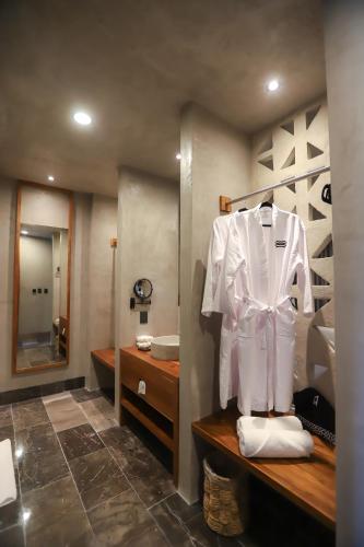 a bathroom with a white shirt on a rack at Hotel Amainah Bacalar Adults Only in Bacalar