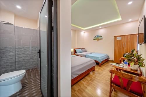 ein Bad mit einem Bett und einem WC in einem Zimmer in der Unterkunft Nam Hội Homestay in Hoi An