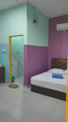 a bedroom with a bed and a colorful wall at Taman negara rainbow guest house in Kuala Tahan