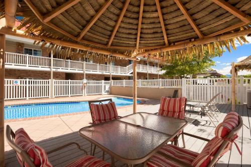 a patio with a table and chairs and a pool at Days Inn by Wyndham Montrose in Montrose