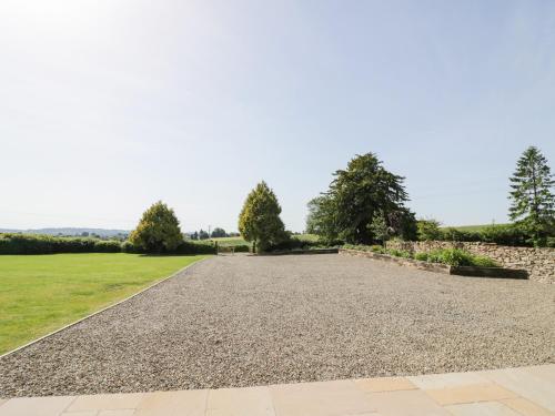 a driveway with gravel and trees in a field at Lea Farm House in Kidderminster