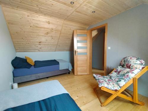 a bedroom with a bed and a chair in a room at Sielsko Anielsko -Domki Swornegacie in Swornegacie 