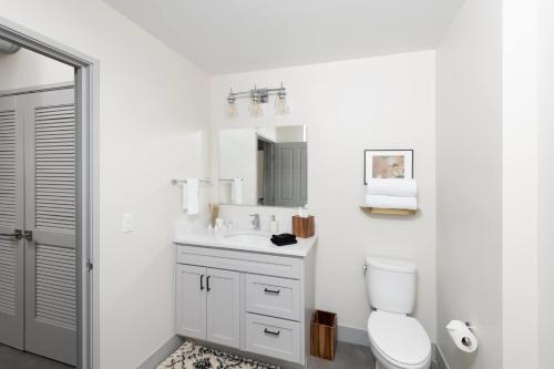 a white bathroom with a toilet and a sink at Flexhome Brewery District 1BR Apt M1 - READ INFO in Milwaukee