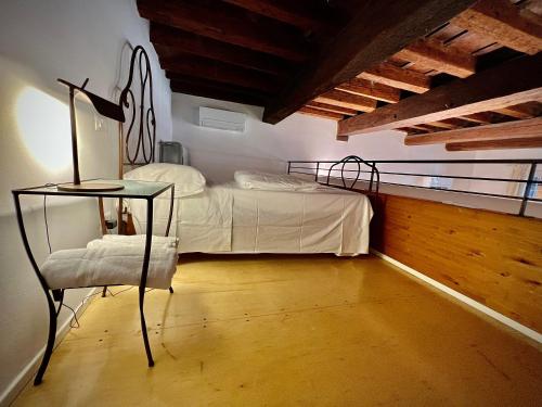 a bedroom with a bed and a chair in a room at La Finestra Sul Ghetto in Padova