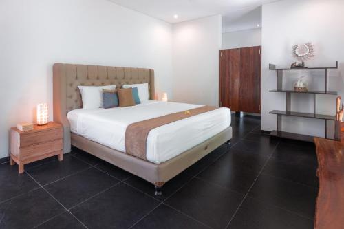 ein Schlafzimmer mit einem großen Bett und einem Nachttisch in der Unterkunft Lempuyang Boutique Hotel in Karangasem