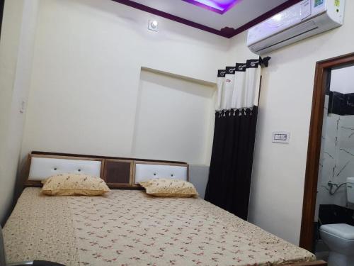 ein Schlafzimmer mit einem Bett mit zwei Kissen darauf in der Unterkunft S A HAVELI GUEST HOUSE in Bikaner