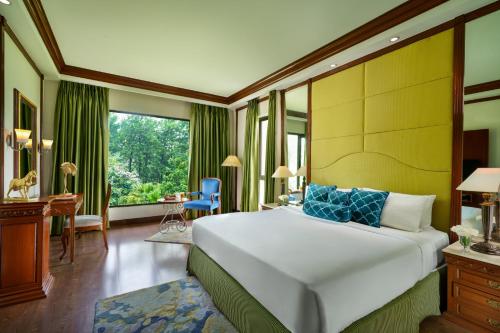a bedroom with a large bed and a desk at Vivanta Katra Vaishno Devi in Katra