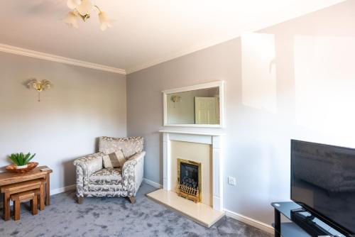 a living room with a fireplace and a chair at Number 4 in Bishop Auckland