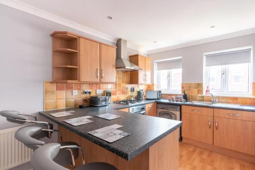 a kitchen with wooden cabinets and a black counter top at Number 4 in Bishop Auckland