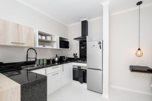 a kitchen with white cabinets and a refrigerator at 31OnGambia in Johannesburg