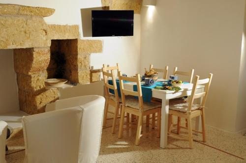 a dining room with a table and chairs and a tv at Holiday home La Corte dei Pirri in Gagliano del Capo