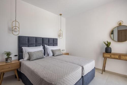 a bedroom with a king sized bed and a mirror at Mystic Garden Villas in Zakynthos Town