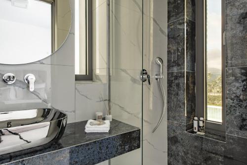 a bathroom with a shower and a sink and a mirror at Mystic Garden Villas in Zakynthos Town