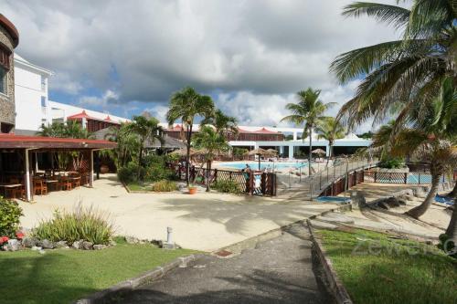 a resort with a swimming pool and palm trees at Appartement Blue Lagon in Saint-François
