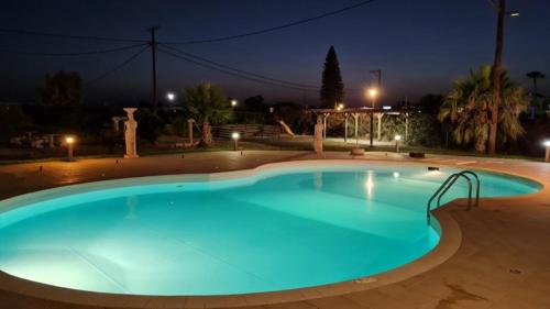 a large blue swimming pool at night at Garden City Image in Tigaki