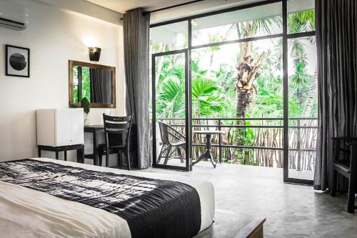 - une chambre avec un lit, un bureau et un balcon dans l'établissement Haven Beach Hiriketiya, Serenevilla Properties, à Dikwella