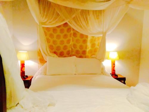 a bedroom with a canopy bed with two lamps at Full Moon Beach Resort in Mui Ne
