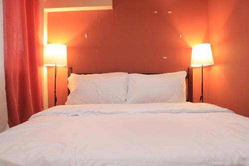 a bedroom with a white bed with two lamps at A2J BGC Luxury 2BR Loft Near Burgos Circle, Malls in Manila