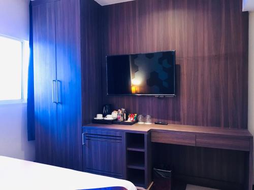 a bedroom with a desk with a tv on a wall at Paradiso Boutique Suites in Bangkok