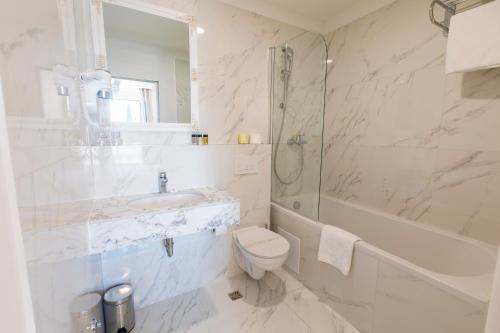 a bathroom with a toilet and a sink and a shower at Art Hotel in Split