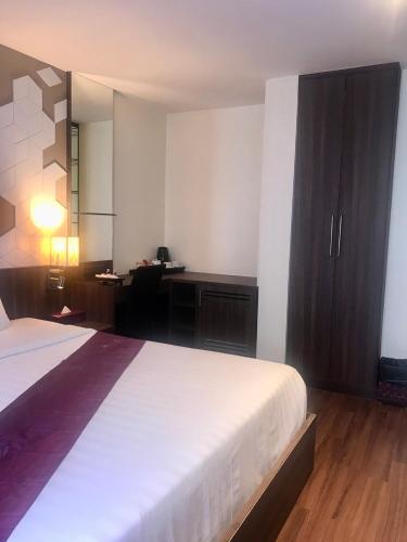 a hotel room with a bed and a desk with a desk at Paradiso Boutique Suites in Bangkok