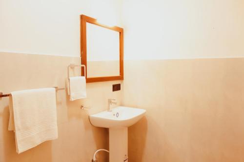 a bathroom with a sink and a mirror at Swan Lake Habarana in Habarana