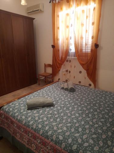 a bedroom with a bed with a dresser and a window at Villetta Simo in Capilungo