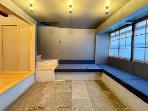 a room with blue seats and a window at TABITABI KANOE MITSU in Kyoto