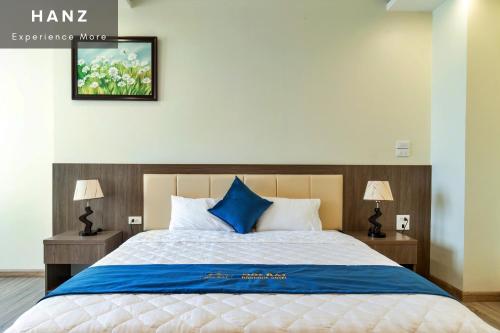 a bedroom with a large bed with blue pillows at S79 Noi Bai Airport Boutique Hotel in Hanoi