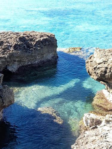 a large body of water with rocks and the ocean at Villetta Simo in Capilungo
