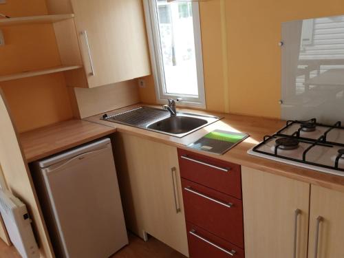 a small kitchen with a sink and a stove at Vue sur mer in Mers-les-Bains