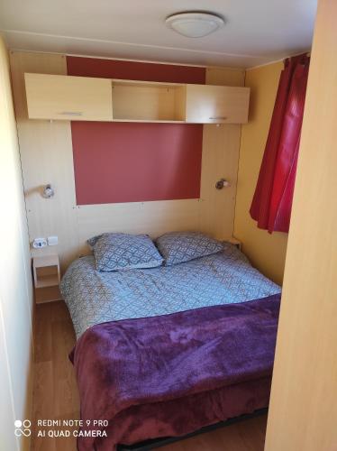 een slaapkamer met een bed in een kleine kamer bij Vue sur mer in Mers-les-Bains