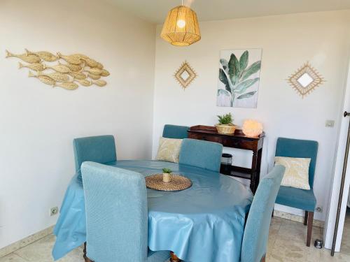 une salle à manger avec une table et des chaises bleues dans l'établissement Beau duplex Cabourg, à Cabourg