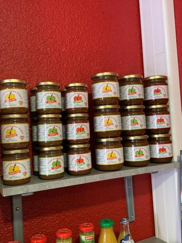 a row of jars of food on a shelf at Initial by balladins Dieppe in Saint-Aubin-sur-Scie