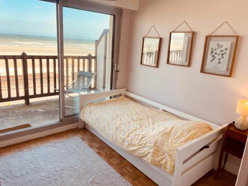 une chambre avec un lit et une vue sur l'océan dans l'établissement Beau duplex Cabourg, à Cabourg