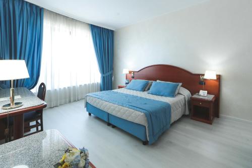 a hotel room with a bed and a desk and a bed sidx sidx sidx sidx at Edra Palace Hotel & Ristorante in Cassino