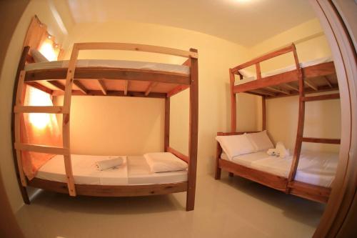 two bunk beds in a room with a mirror at Baletin Hometel in Basco