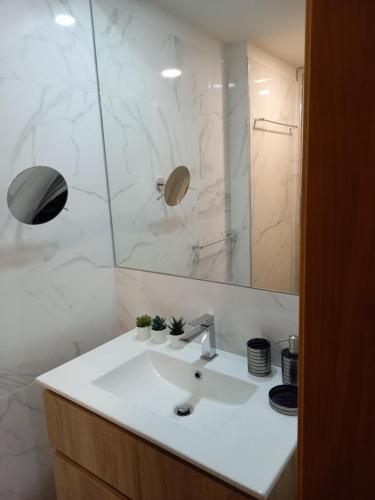 uma casa de banho com um lavatório branco e um espelho. em Casa MIRA DOURO em Vila Nova de Gaia