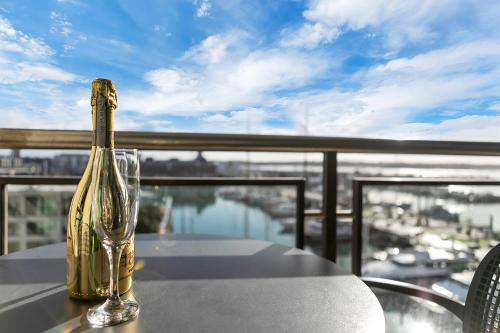 a bottle of champagne sitting on a table on a balcony at Penthouse Glory in Auckland