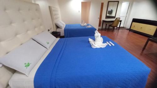 two beds in a room with blue sheets at Town and Country Hotel V Mapa in Manila