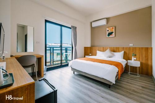 a hotel room with a bed and a large window at Penghu Lemongrass in Magong