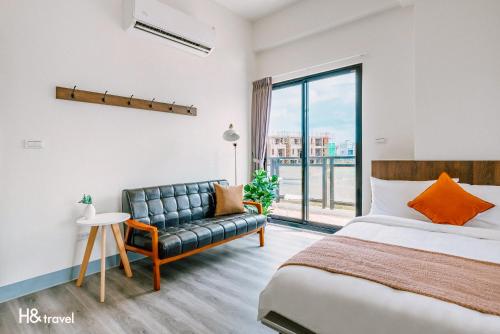 1 dormitorio con cama, sofá y ventana en Penghu Lemongrass en Magong