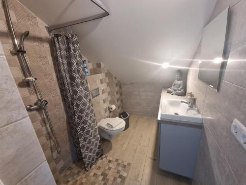 a bathroom with a toilet and a sink at Ventė Stay apartment in Ventė