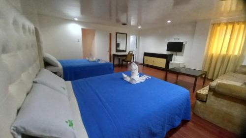 a living room with two blue beds and a couch at Town and Country Hotel V Mapa in Manila