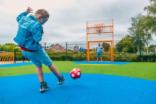 a man kicking a soccer ball on a field at Europarcs Zuiderzee in Biddinghuizen