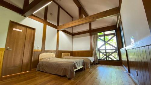 大崎市にあるTabinoteitaku Yakurai Cottageのベッド2台と窓のある病室です。