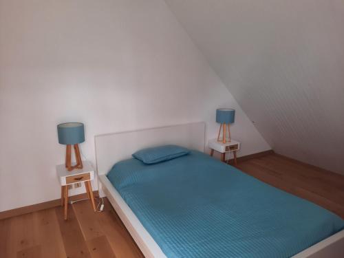 ein kleines Schlafzimmer mit einem Bett und zwei Lampen in der Unterkunft Les embruns in Saint-Philibert