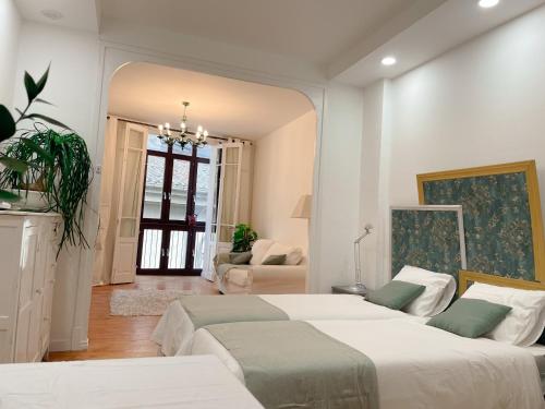een slaapkamer met 2 bedden en een woonkamer bij Habitación Centro Pamplona - acceso independiente in Pamplona
